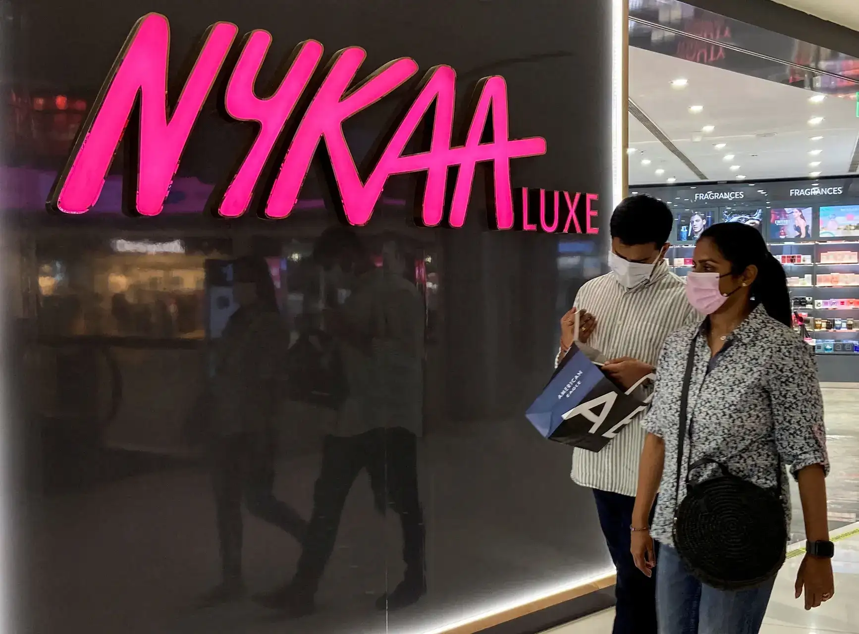 FILE PHOTO: People walk past a store of Nykaa, an Indian beauty products retailer, at a mall in New Delhi